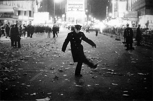 foto Joel Meyerowitz poliziotto calcia cartaccia strada