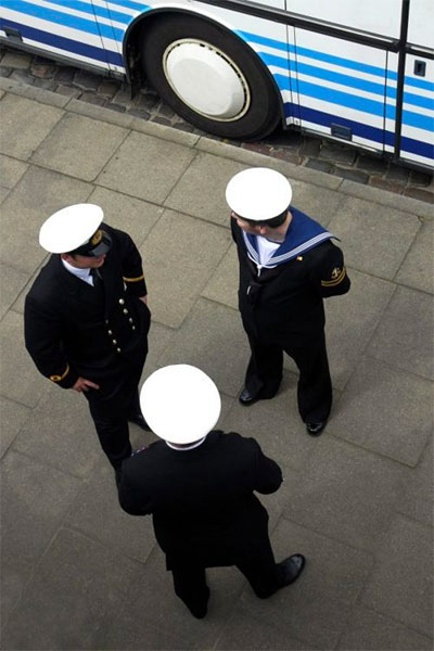 street photography Siegfried Hansen tre marinai cappelli e ruota bus similitudine